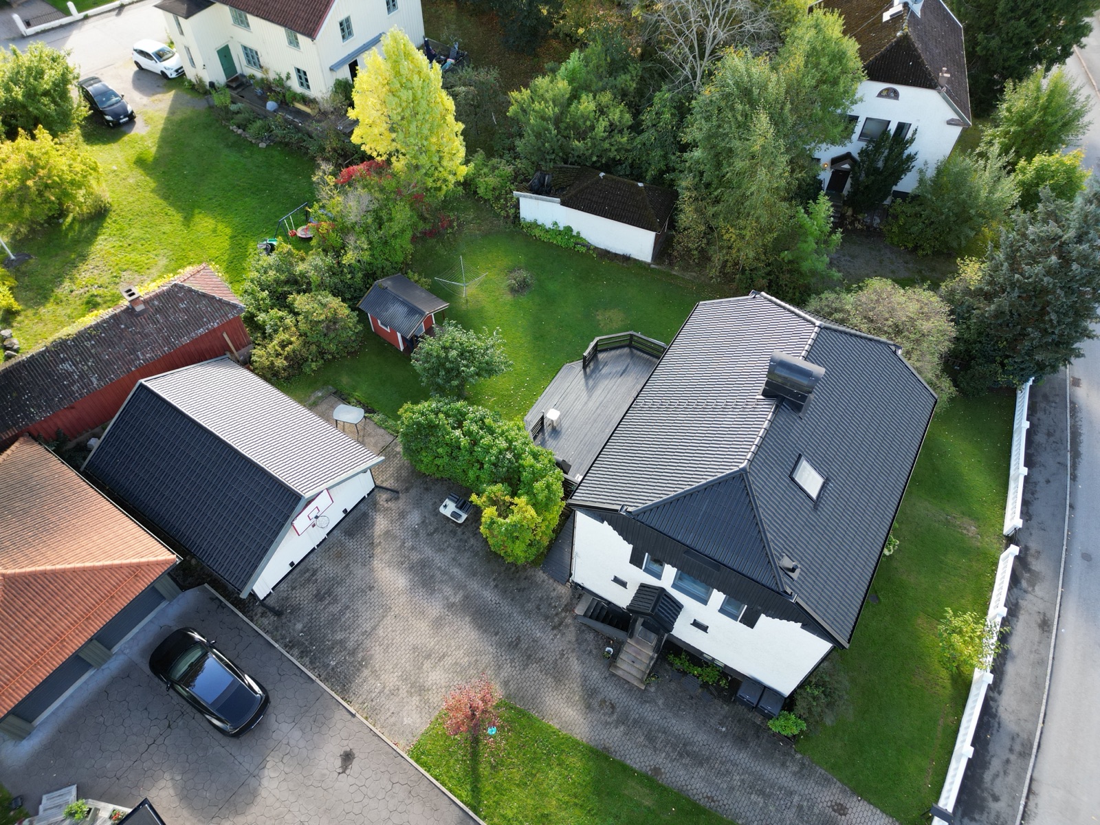 Villa med nytt mörkt tak, garage och tomt sedda uppifrån – Borås