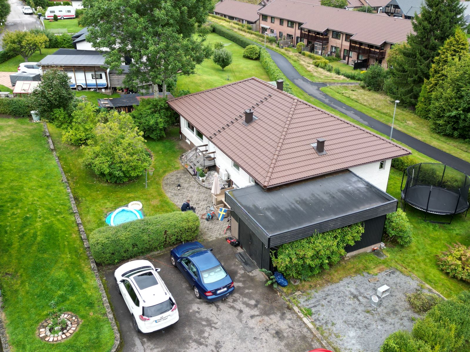 Villa med nytt brunt tak och carport sedd från sidan – Skene