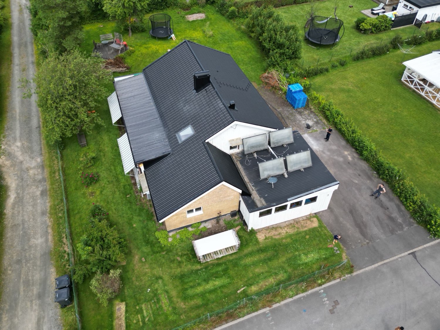 Villa med flera takfall och två olika taktäckningar, sett från drönare